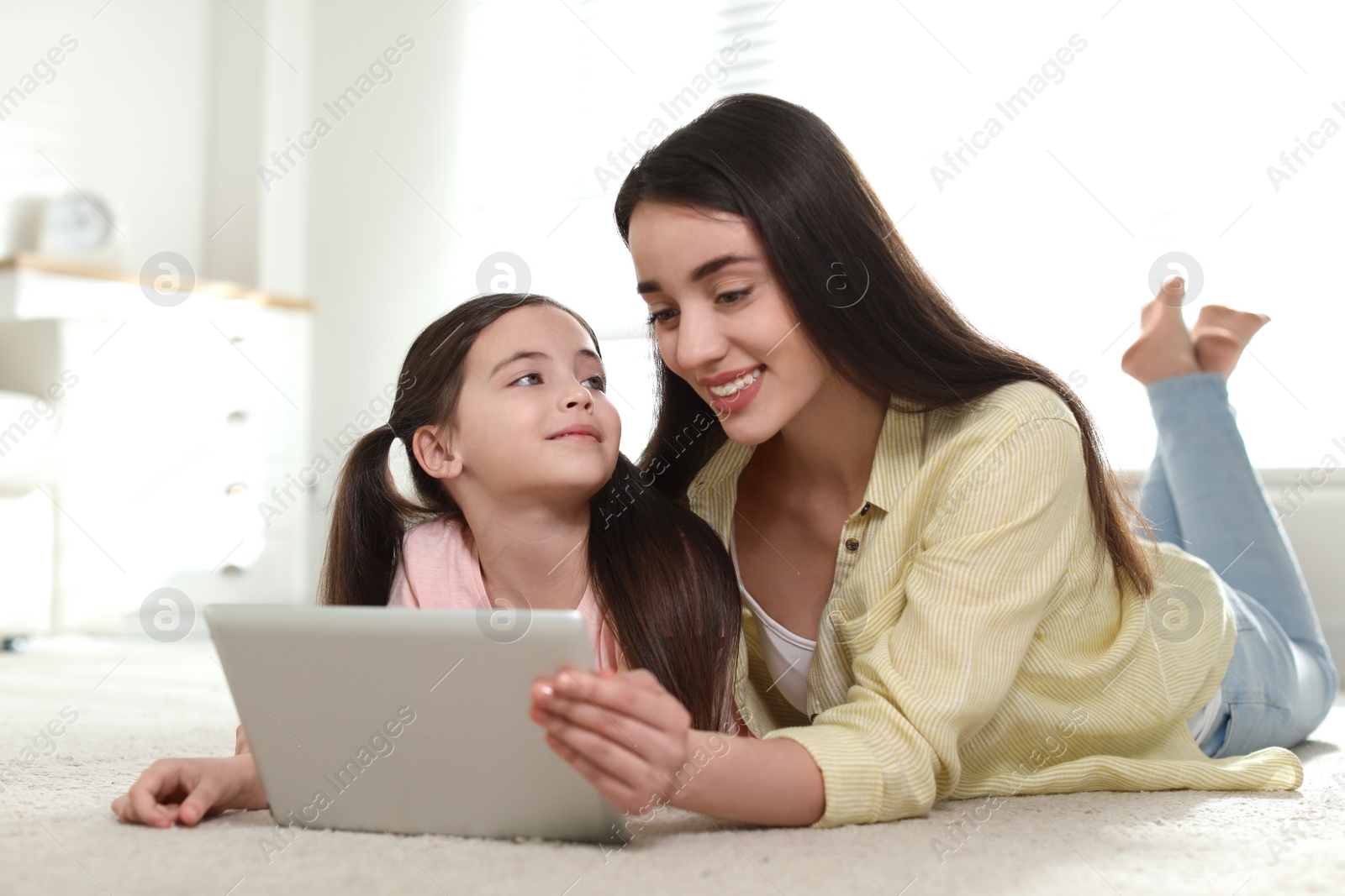 Photo of Mother and daughter reading E-book together at home