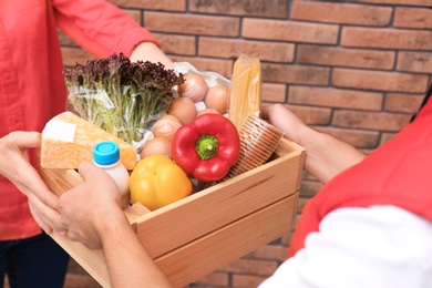 Male courier delivering food to client indoors, closeup