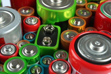 Many batteries of different types as background, closeup view