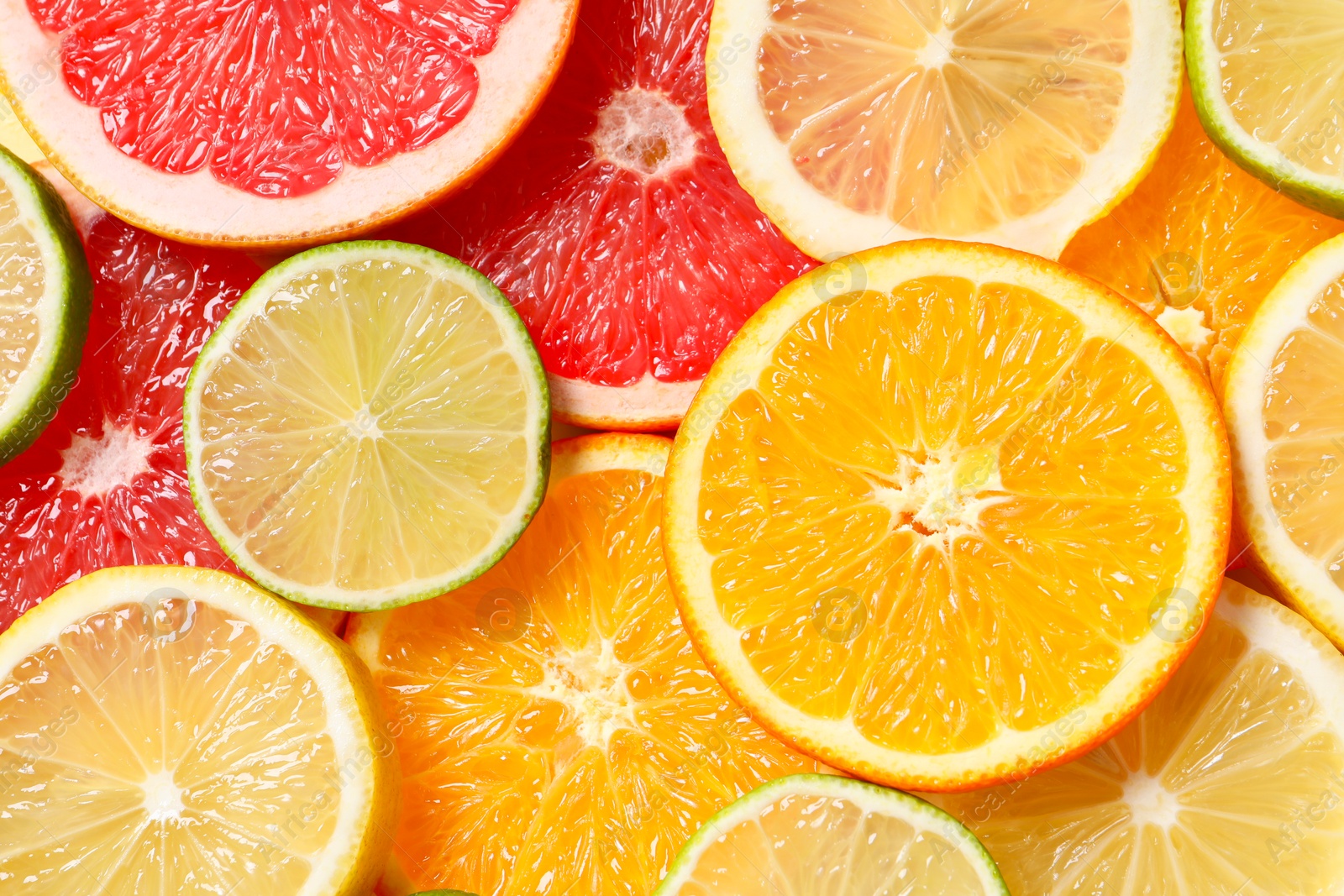 Photo of Different sliced citrus fruits as background, top view