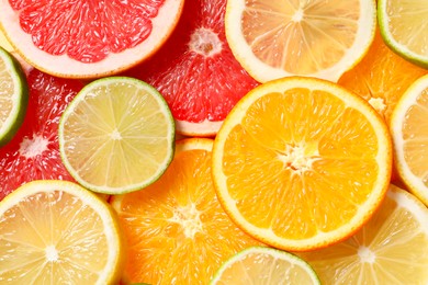 Photo of Different sliced citrus fruits as background, top view