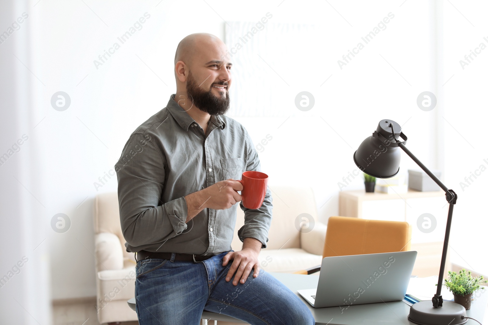 Photo of Portrait of confident young man drinking coffee in room