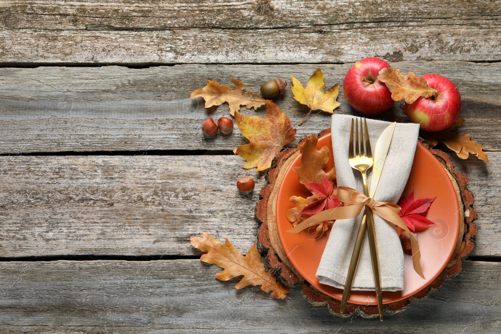 Photo of Festive table setting with autumn decor and apples on wooden background, flat lay. Space for text
