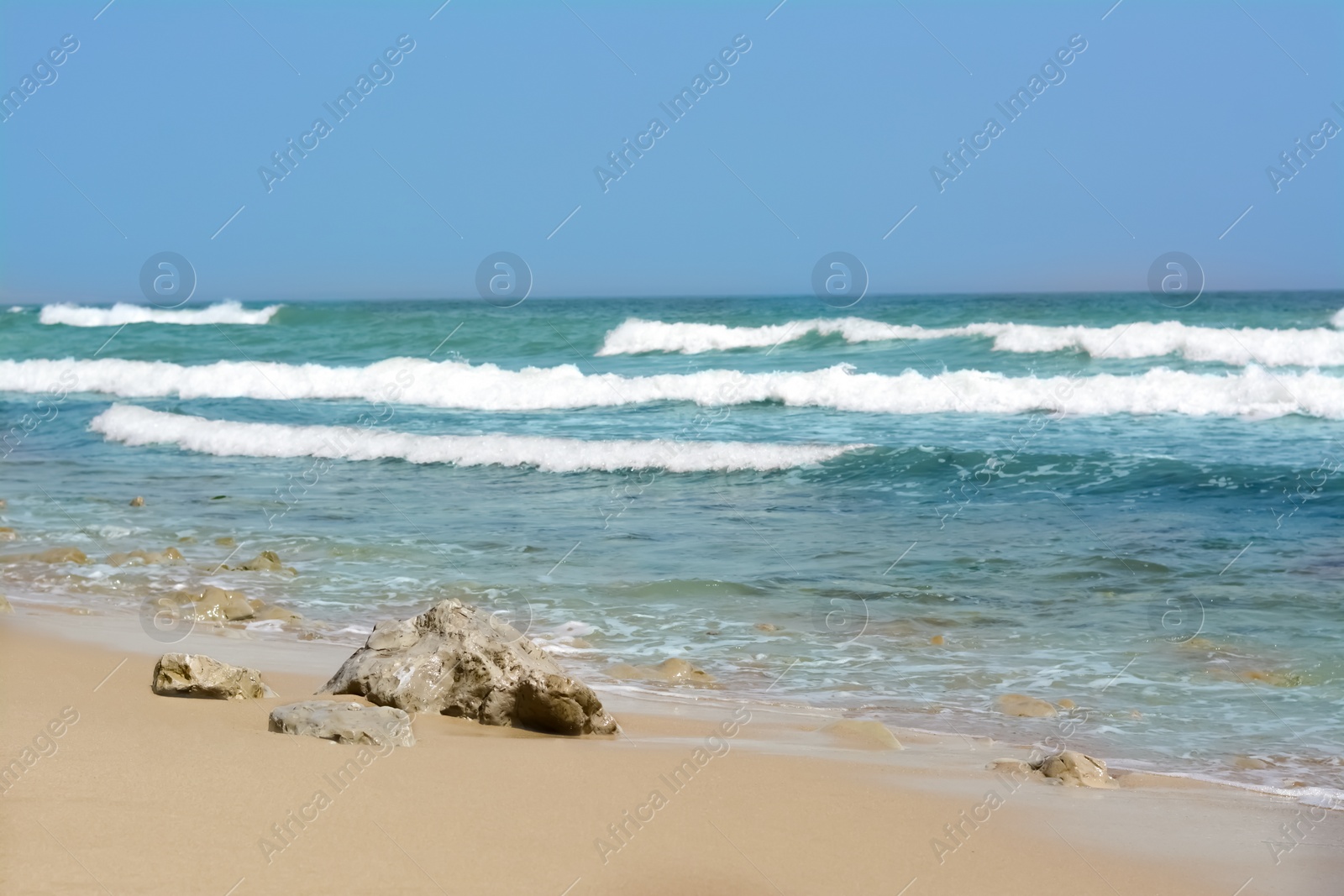 Photo of Beautiful view of sandy beach with rocks and sea. Summer vacation