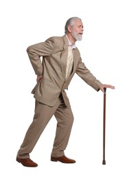 Senior man with walking cane suffering from back pain on white background