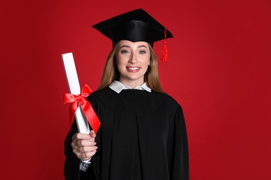 Photo of Happy student with diploma on red background