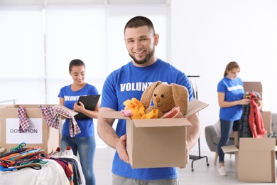 Male volunteer holding box with donations indoors