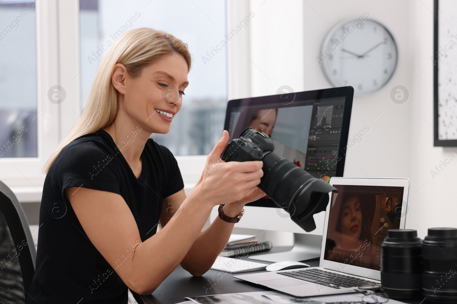 Photo of Professional photographer with digital camera at table in office