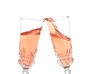 Photo of Toasting with glasses of rose champagne on white background