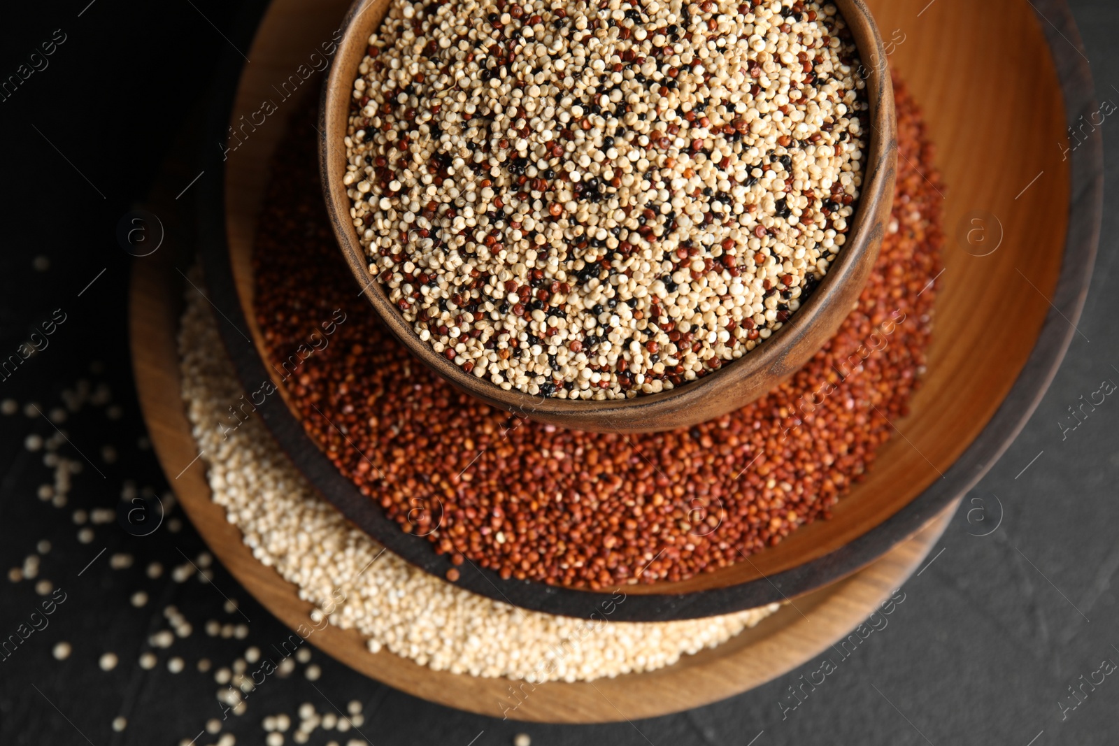 Photo of Composition with different types of quinoa on black background, top view