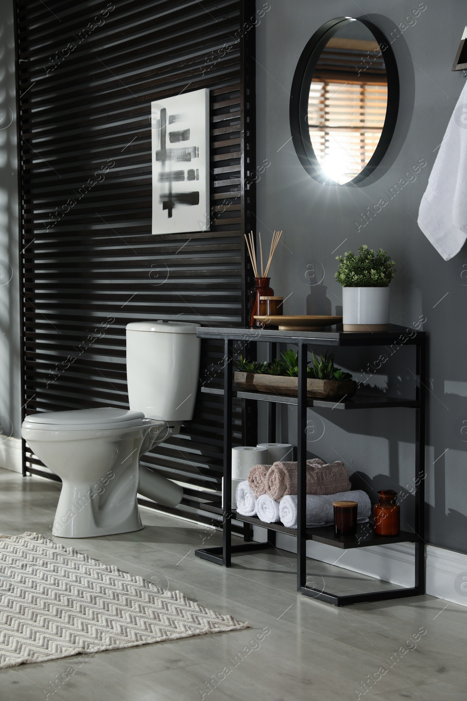 Photo of Modern bathroom interior with toilet bowl and console table