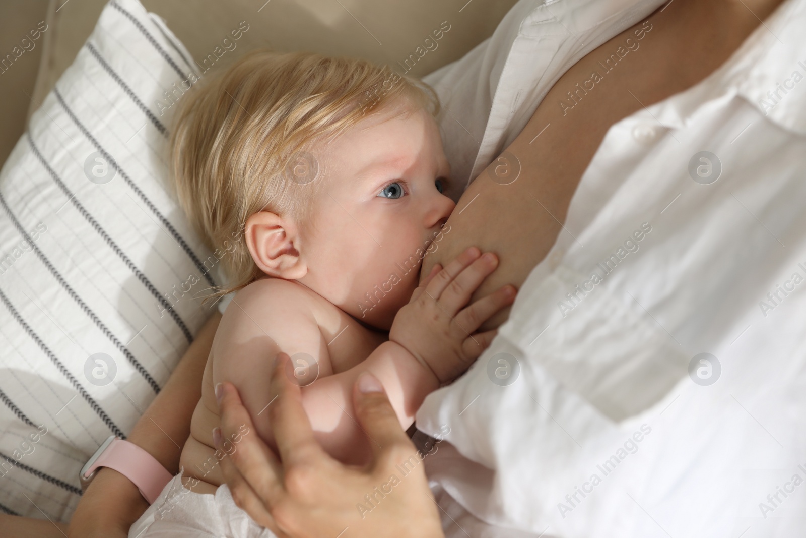 Photo of Mother breastfeeding her little baby at home. Healthy growth