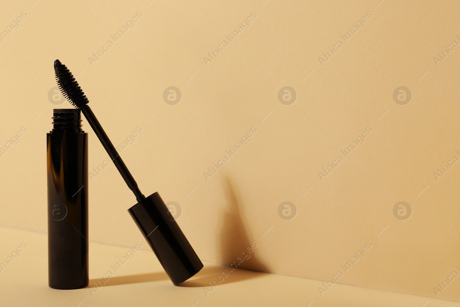 Photo of Mascara on beige background, space for text. Makeup product