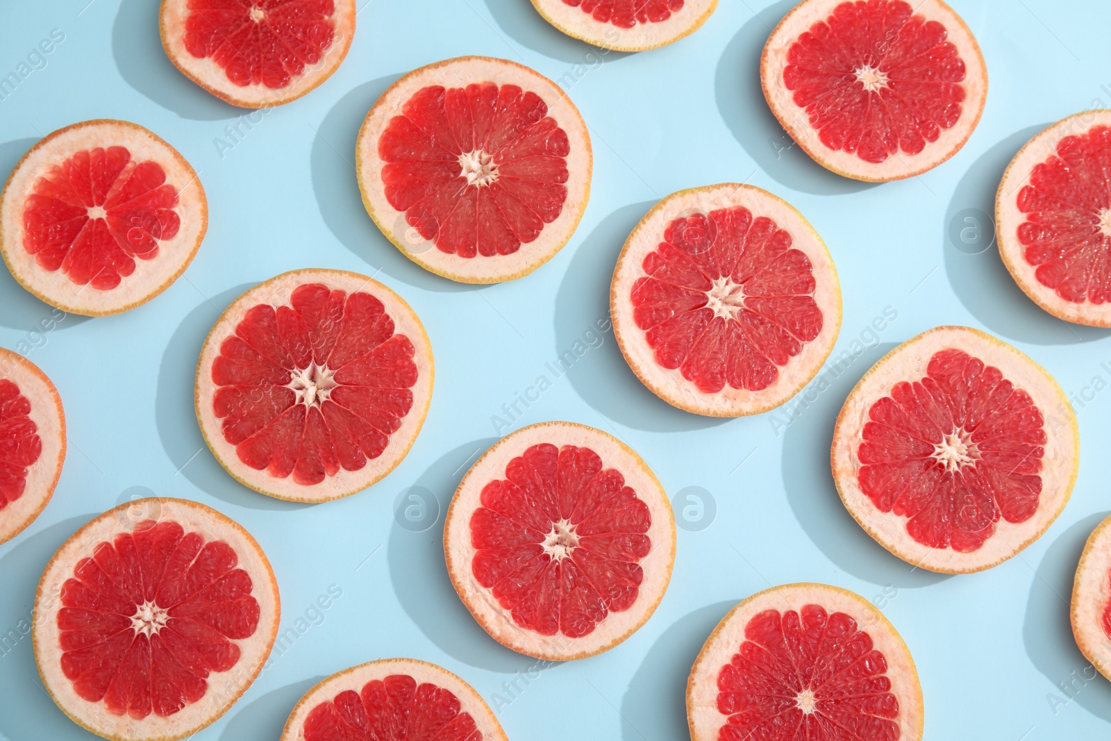 Photo of Fresh sliced ripe grapefruit on color background, flat lay