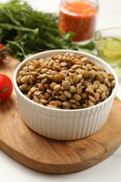 Photo of Delicious lentils in bowl served on table, closeup