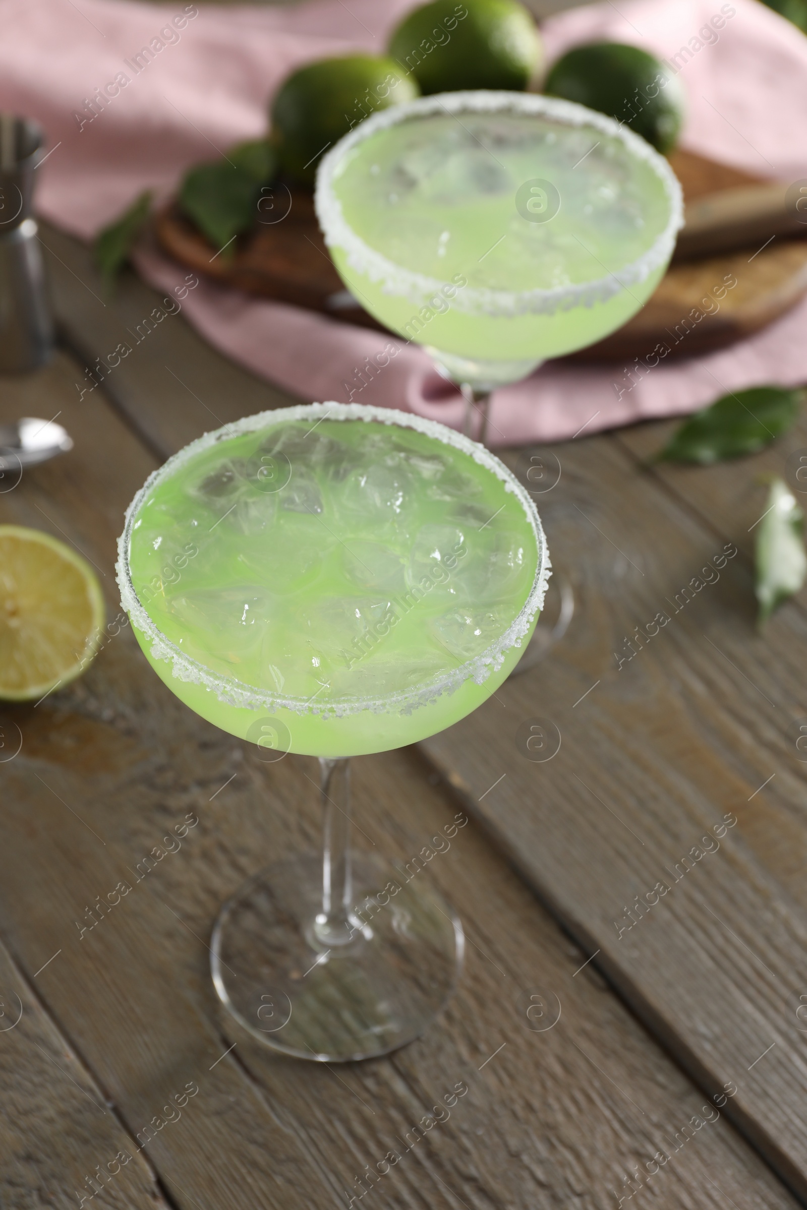 Photo of Delicious Margarita cocktail in glasses on wooden table, closeup