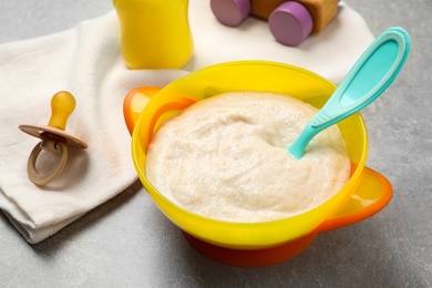 Photo of Healthy baby food in bowl on grey table