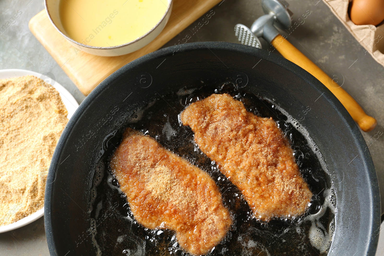 Photo of Cooking schnitzels in frying pan, above view