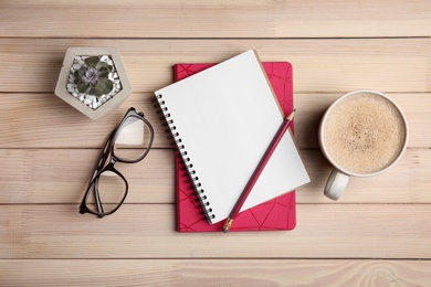 Flat lay composition with office stationery and cup of coffee on wooden table