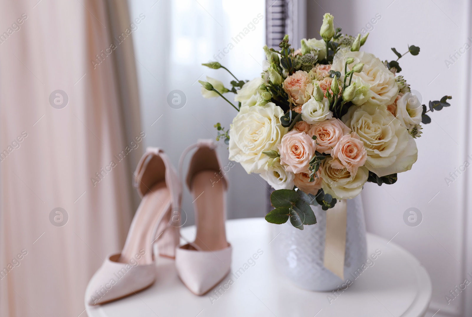 Photo of Beautiful wedding bouquet and shoes on white table indoors