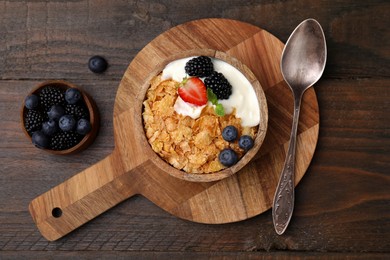 Delicious crispy cornflakes, yogurt and fresh berries served on wooden table, flat lay. Healthy breakfast