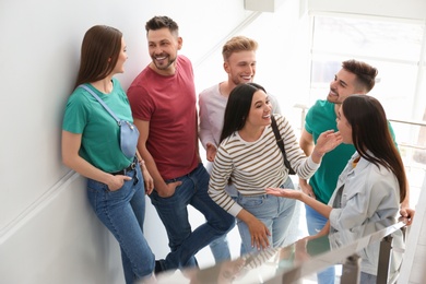 Photo of Group of happy people going up stairs indoors