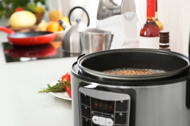 Photo of Modern multi cooker with buckwheat on table. Space for text
