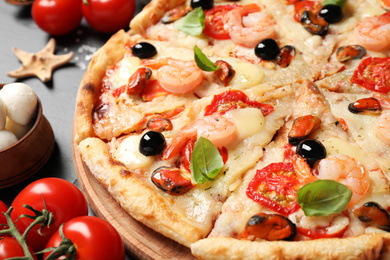 Tasty fresh pizza with seafood on table, closeup