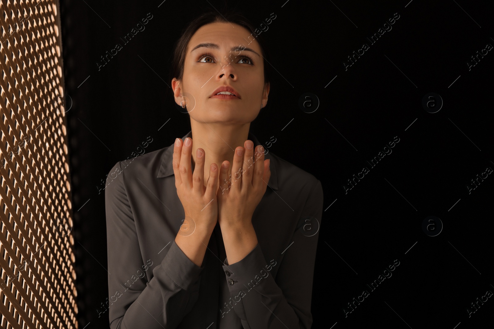 Photo of Woman praying to God during confession in booth, space for text