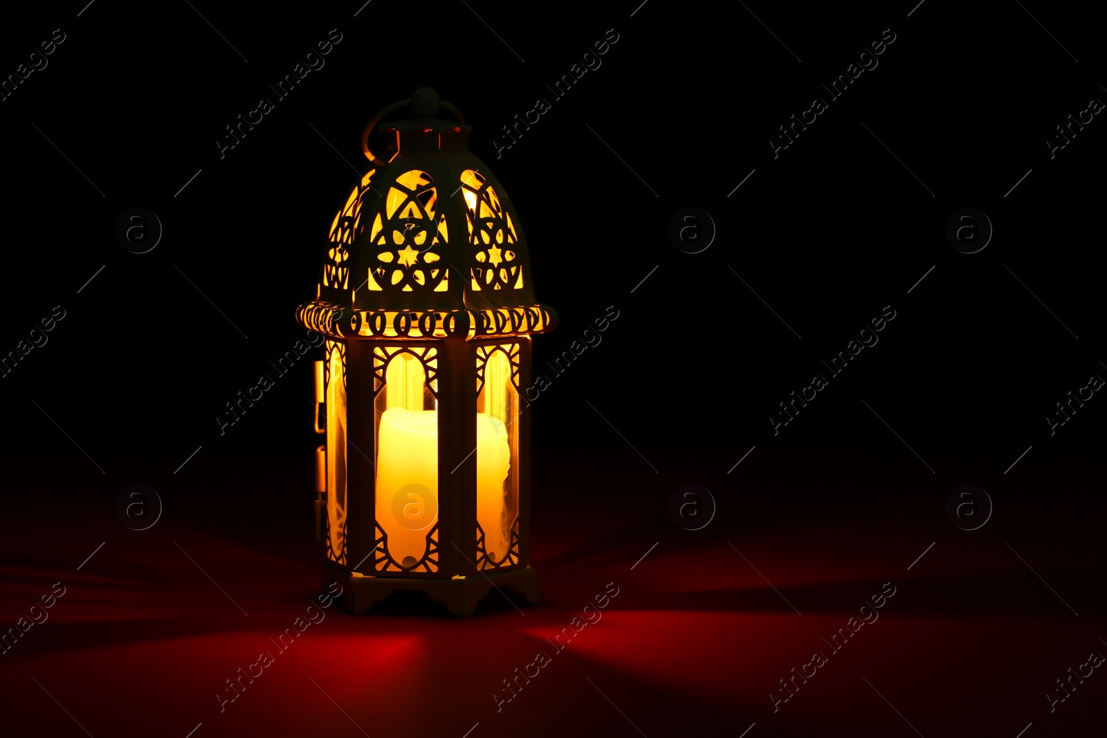 Photo of Decorative Arabic lantern on table against dark background. Space for text