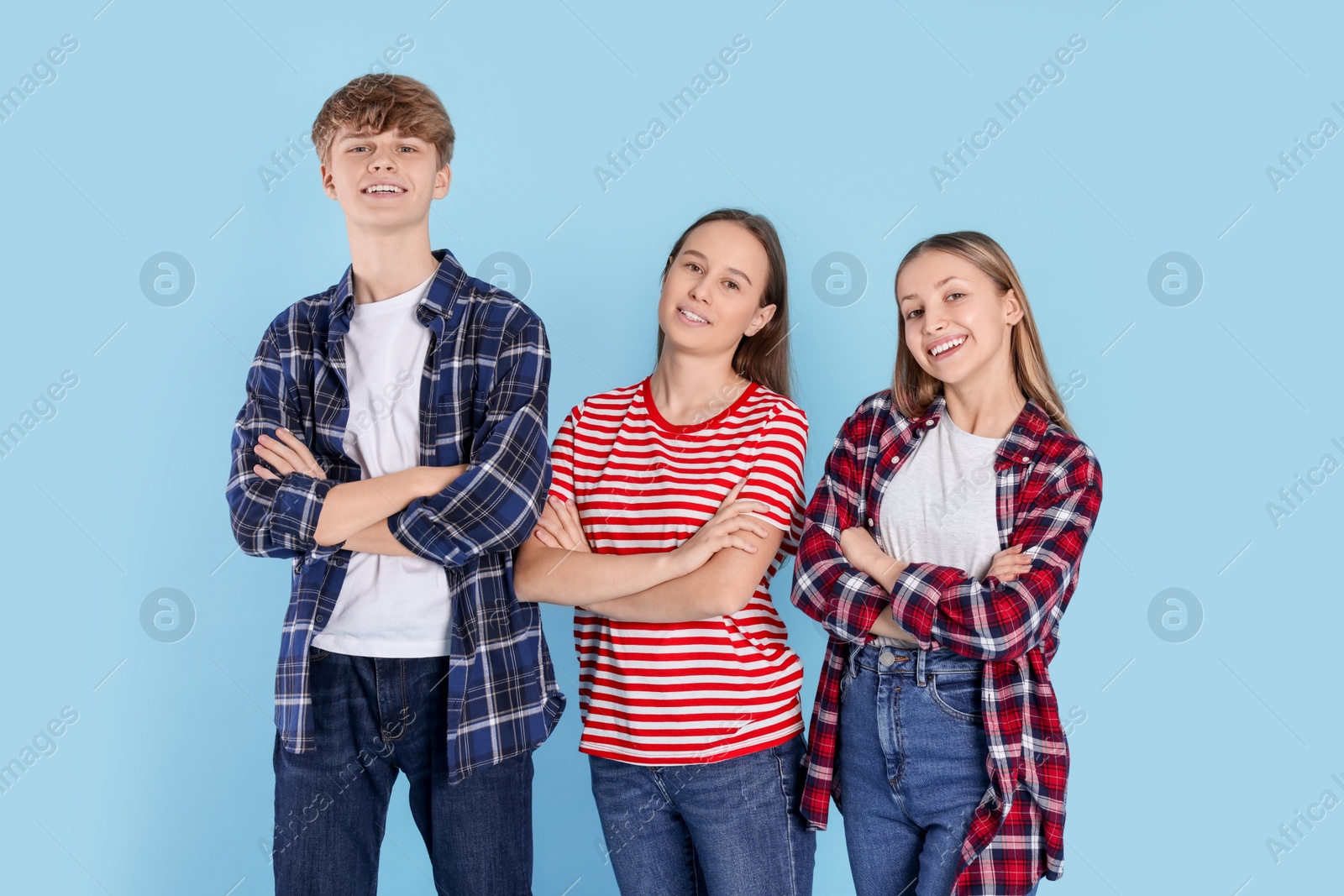 Photo of Group of happy teenagers on light blue background