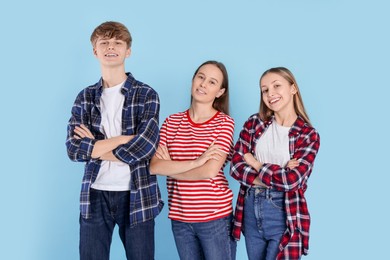 Group of happy teenagers on light blue background