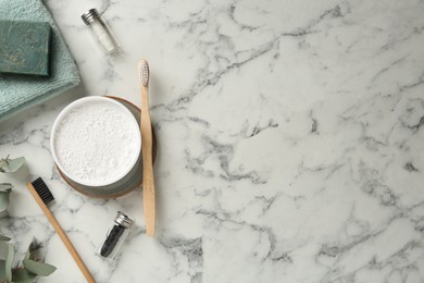 Flat lay composition with tooth powder and brushes on white marble table. Space for text