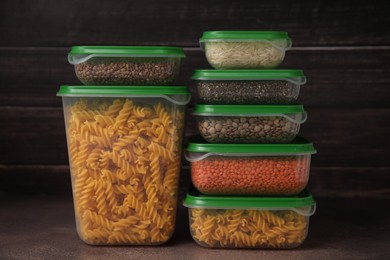 Photo of Plastic containers filled with food products on brown table