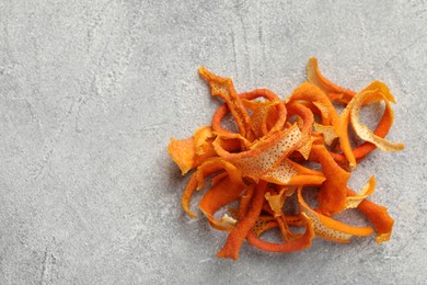 Photo of Dry orange peels on light gray textured table, above view. Space for text