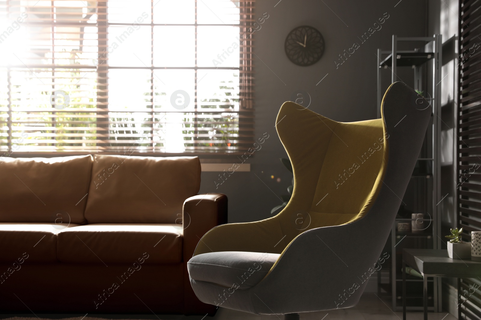 Photo of Stylish living room interior with comfortable armchair and leather sofa