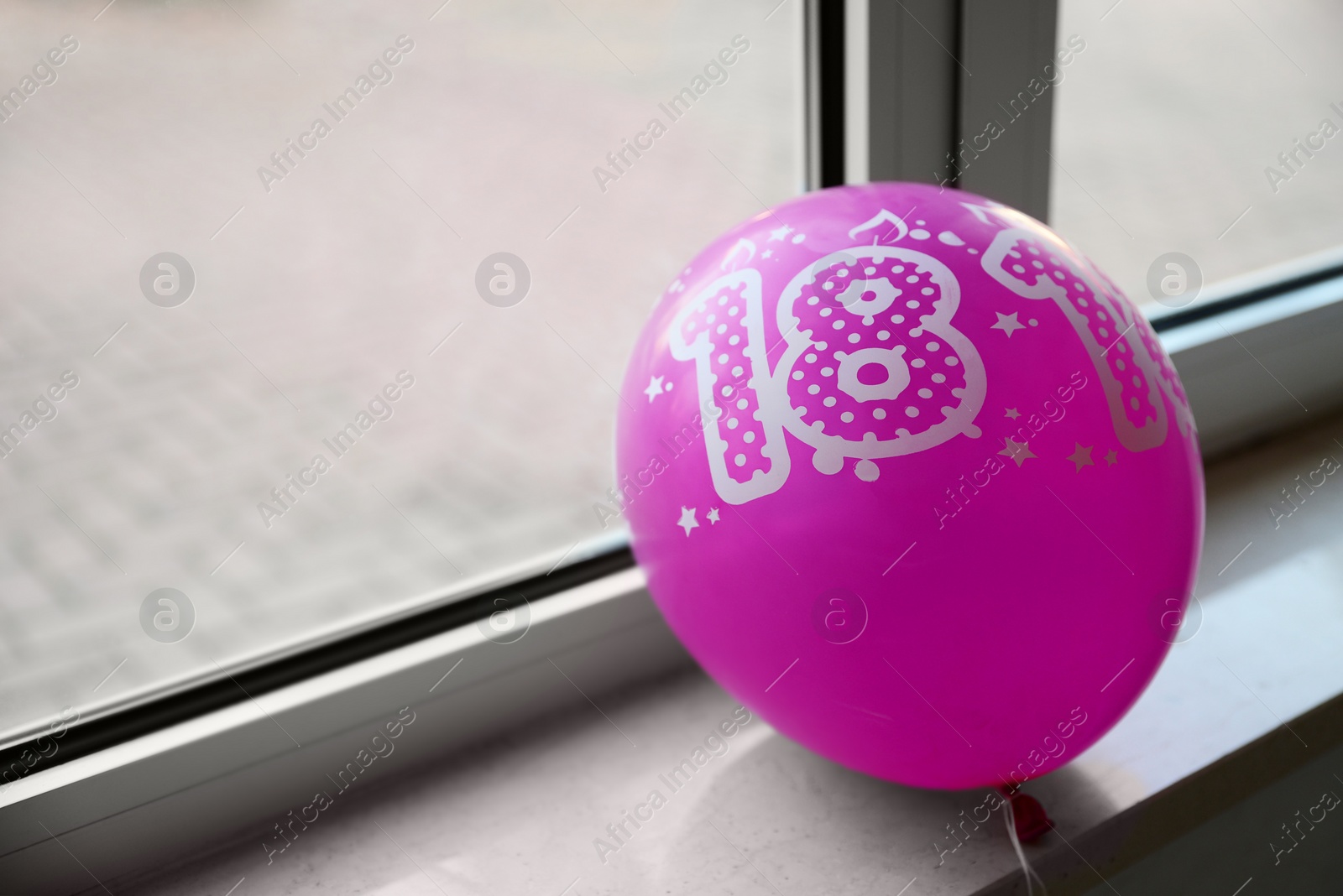 Photo of Pink balloon with number 18 as birthday candles on windowsill indoors, space for text. Coming of age party