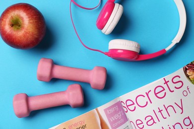 Photo of Flat lay composition with dumbbells on light blue background