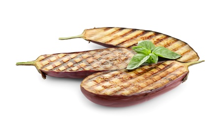Photo of Delicious grilled eggplant halves and basil on white background