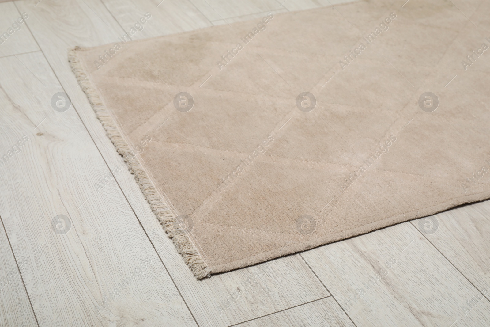 Photo of Soft beige carpet on white laminated floor indoors