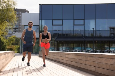 Photo of Healthy lifestyle. Happy couple running outdoors on sunny day, space for text