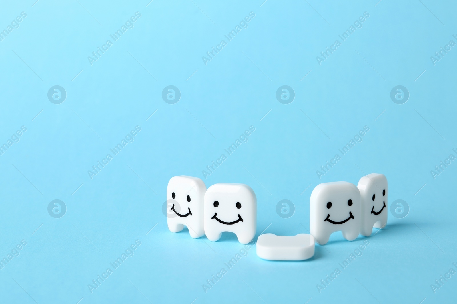 Photo of Composition with small plastic teeth on color background. Space for text