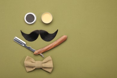 Photo of Artificial moustache and barber tools on khaki background, flat lay. Space for text