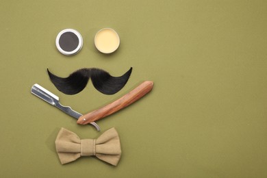 Artificial moustache and barber tools on khaki background, flat lay. Space for text