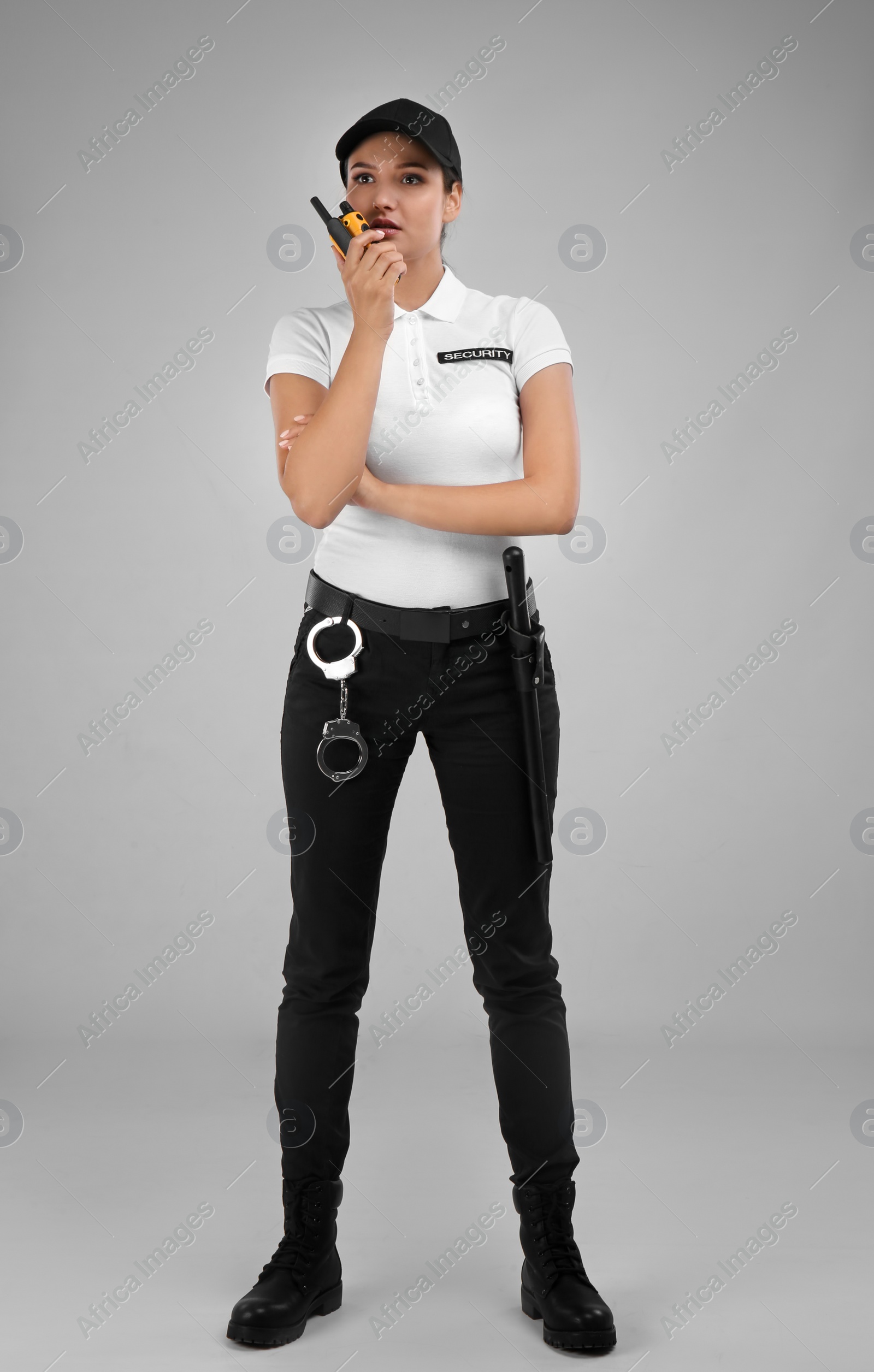 Photo of Female security guard using portable radio transmitter on color background