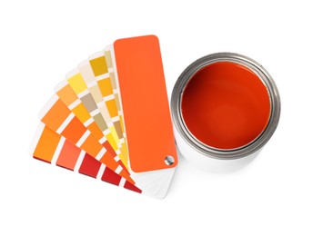 Photo of Can with orange paint and palette samples on white background, above view