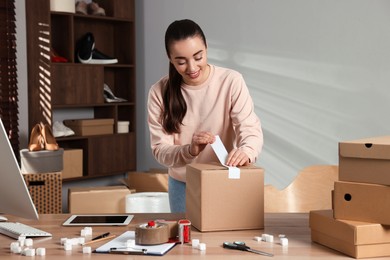 Photo of Seller taping parcel at workplace. Online store