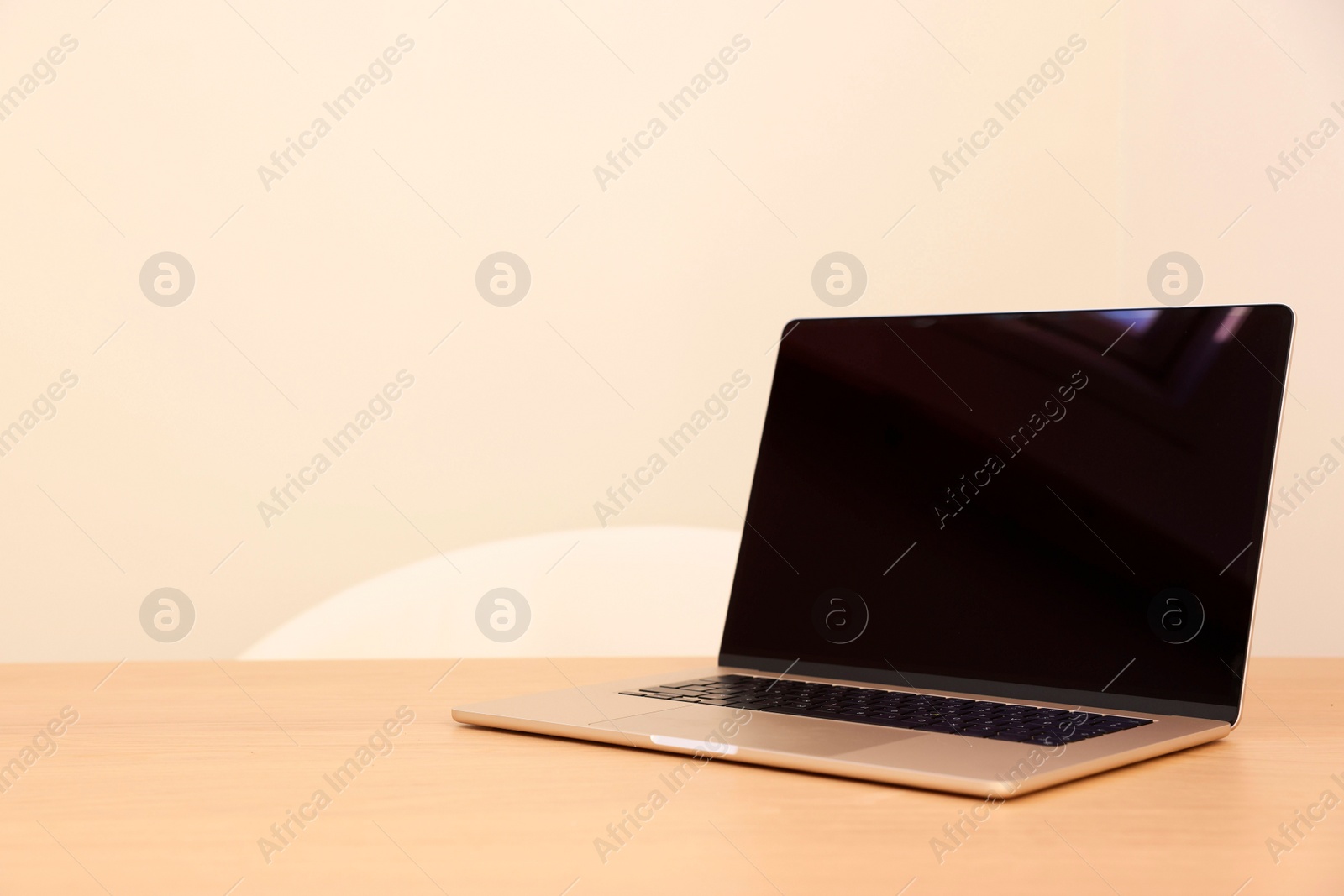 Photo of Modern laptop on wooden table. Space for text