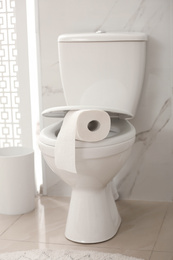 Photo of Paper roll on toilet bowl in bathroom