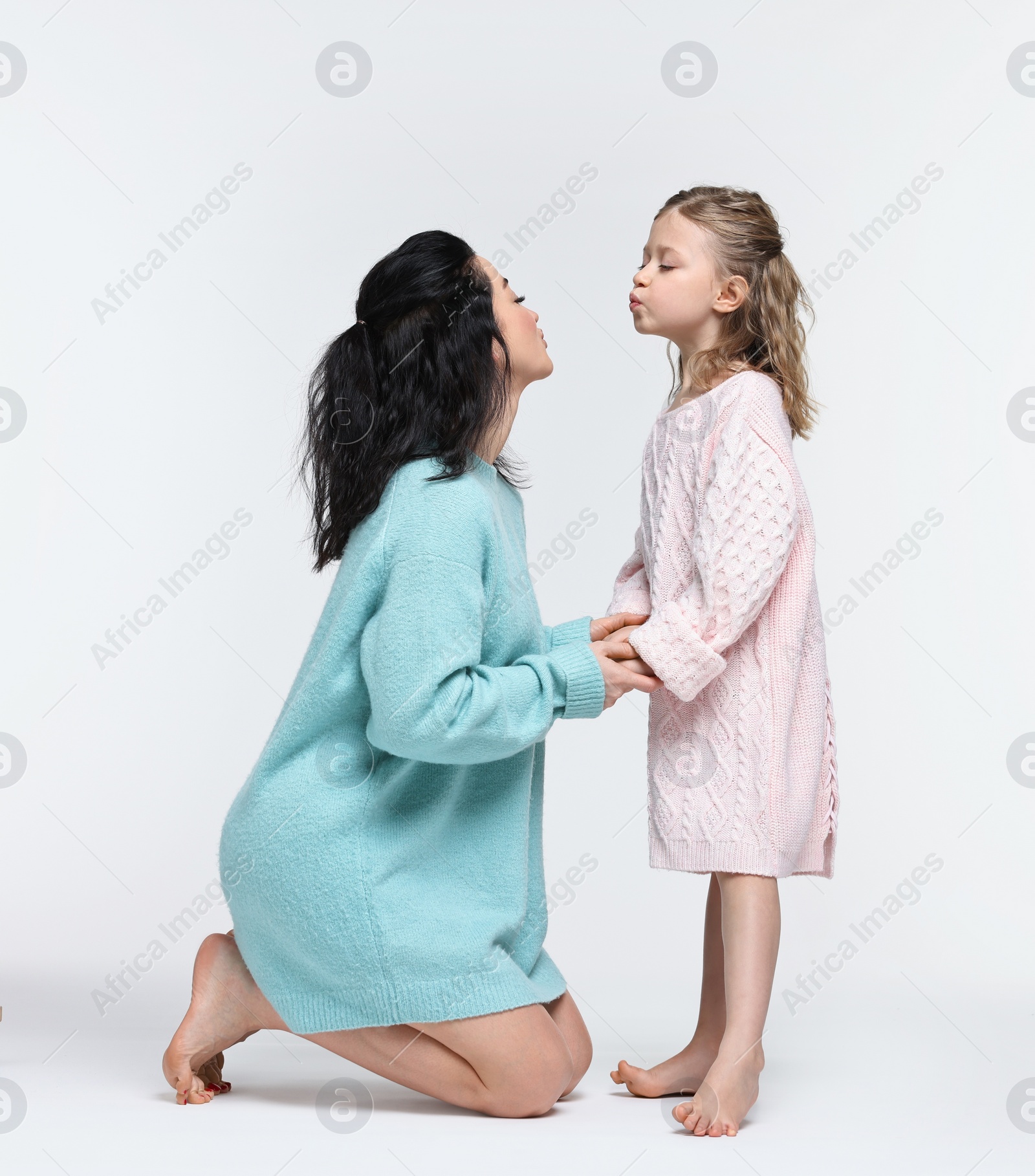 Photo of Beautiful mother with little daughter on white background